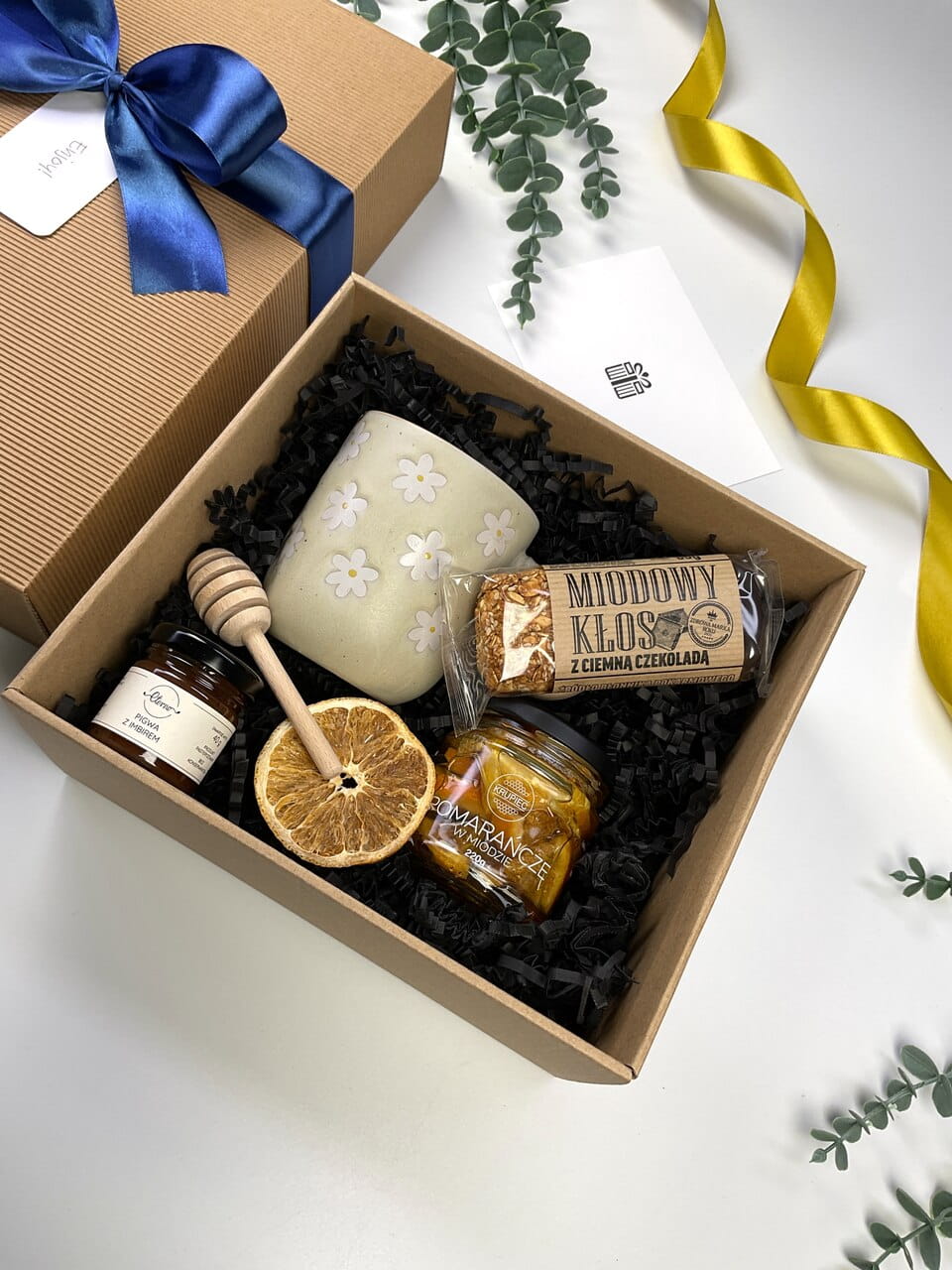 Naturalny box prezentowy ryflowany z kubkiem w kwiaty, pomarańczami w miodzie i batonem miodowym. Idealny zestaw upominkowy na wiosnę.