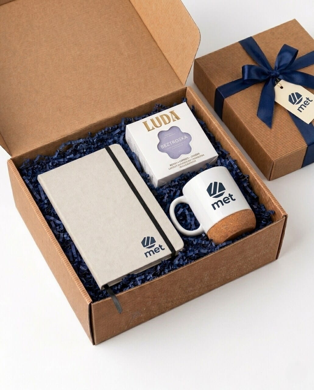 Personalizowany welcome pack dla pracownika z logo firmy. W zestawie elegancki notatnik, kubek z korkowym dnem i herbata premium. Profesjonalny pakiet powitalny wspierający employer branding i onboarding w Twojej firmie.