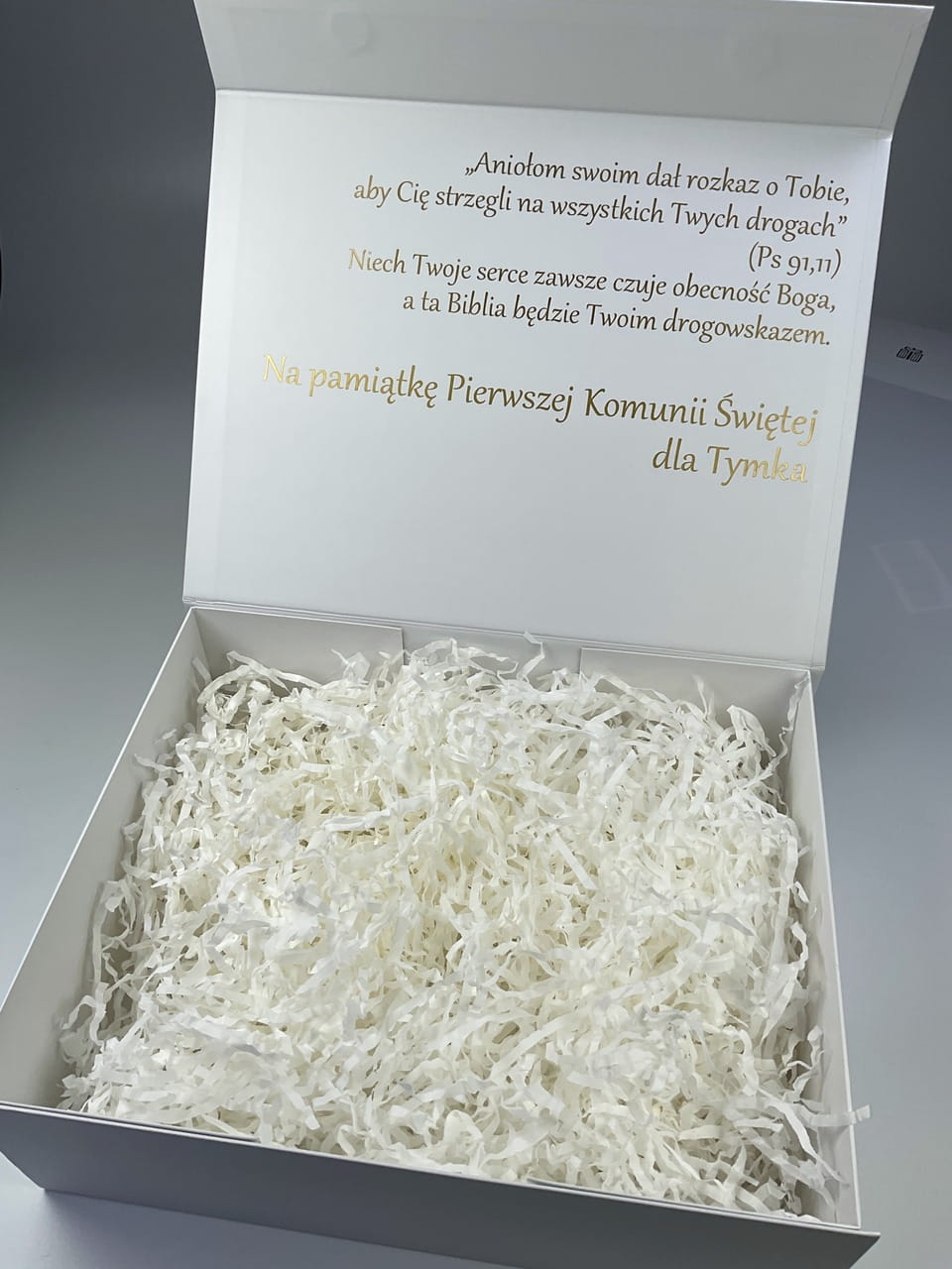 Jak zapakować Biblię na Komunię? Eleganckie białe pudełko z personalizacją, wstążką i życzeniami w środku.