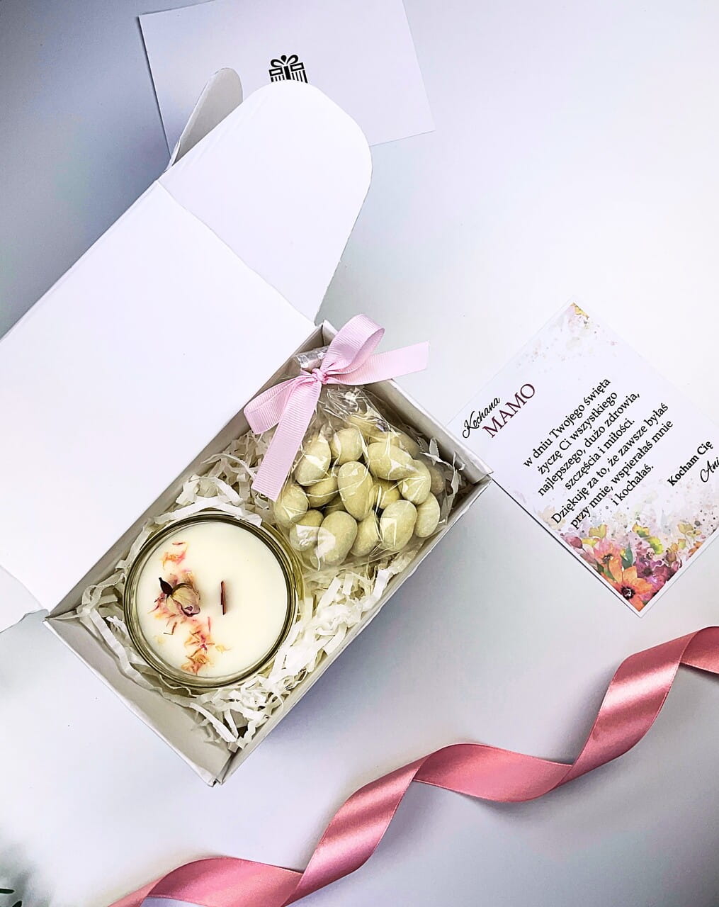 Personalizowana kartka z życzeniami dla mamy obok zestawu ze świecą rzemieślniczą.