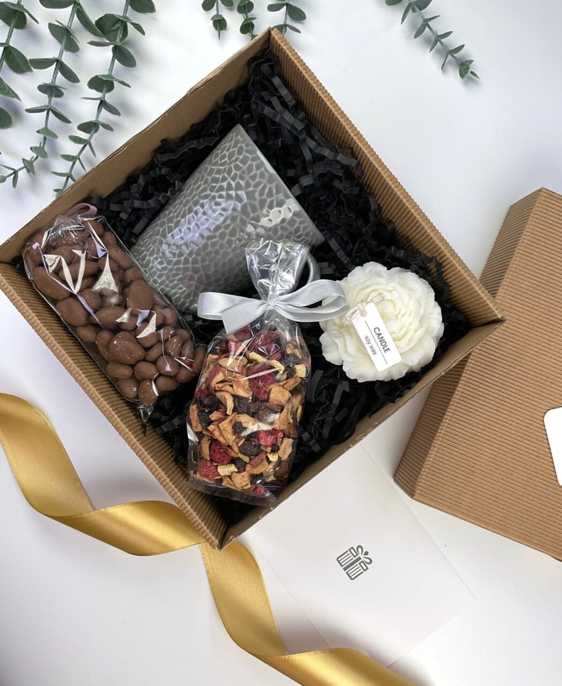 zestaw box prezentowy na dzień nauczyciela imieniny lub urodziny który zawiera szary nowoczesny kubek, ręcznie robioną naturalną świecę sojową, orzechy w mlecznej czekoladzie, herbatę z różą i lawendą