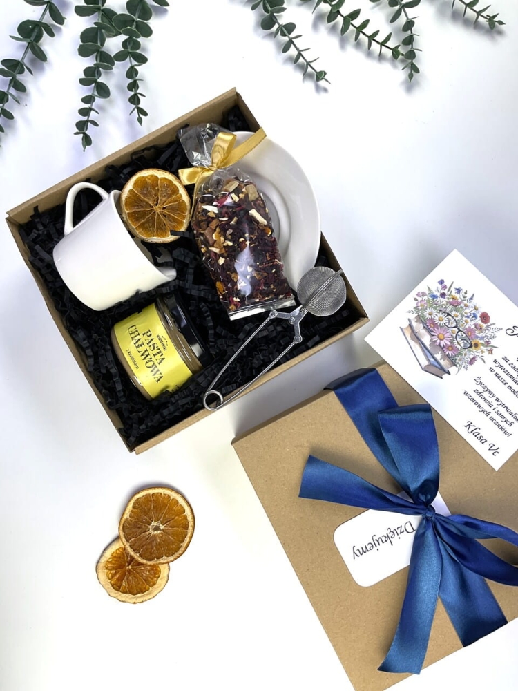 Personalizowany prezent na zakończenie roku szkolnego. Podaruj nauczycielowi chwilę relaksu z pyszną pastą chałwową, aromatyczną herbatą i klasyczną filiżanką. Piękne ekologiczne pudełko z elegancką granatową kokardą.