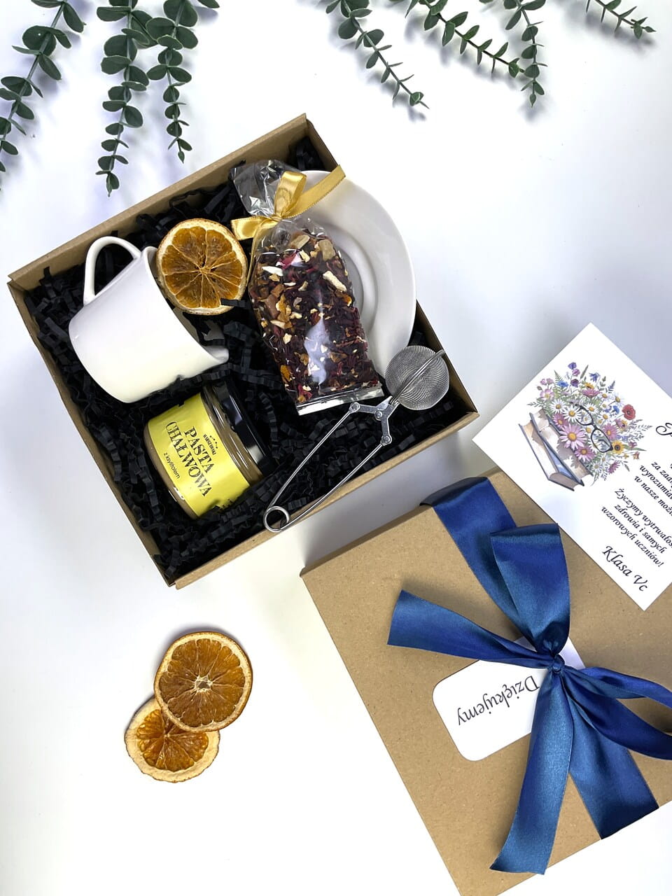 Personalizowany prezent na zakończenie roku szkolnego. Podaruj nauczycielowi chwilę relaksu z pyszną pastą chałwową, aromatyczną herbatą i klasyczną filiżanką. Piękne ekologiczne pudełko z elegancką granatową kokardą.