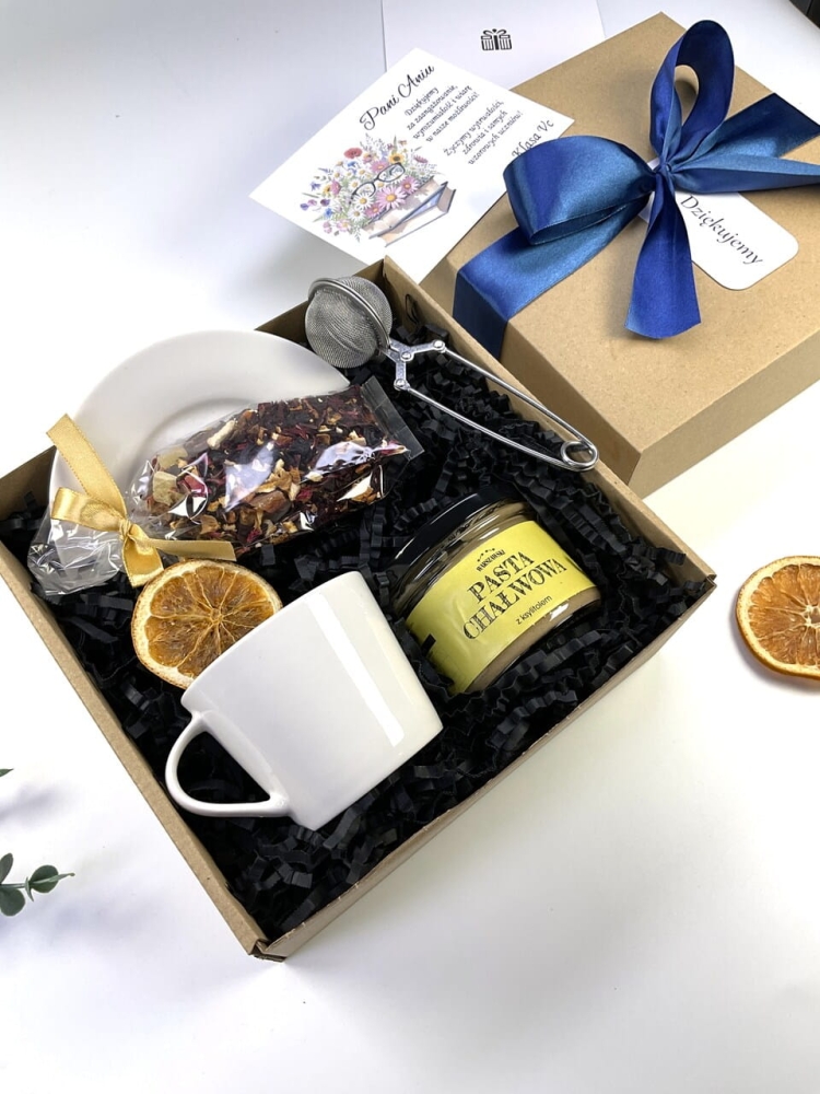 Idealny pomysł na prezent dla nauczycielki. Zestaw premium z porcelanową filiżanką, naturalną pastą chałwową i aromatyczną herbatą. Całość zamknięta w stylowym pudełku z granatową wstążką oraz dedykacją od całej klasy.