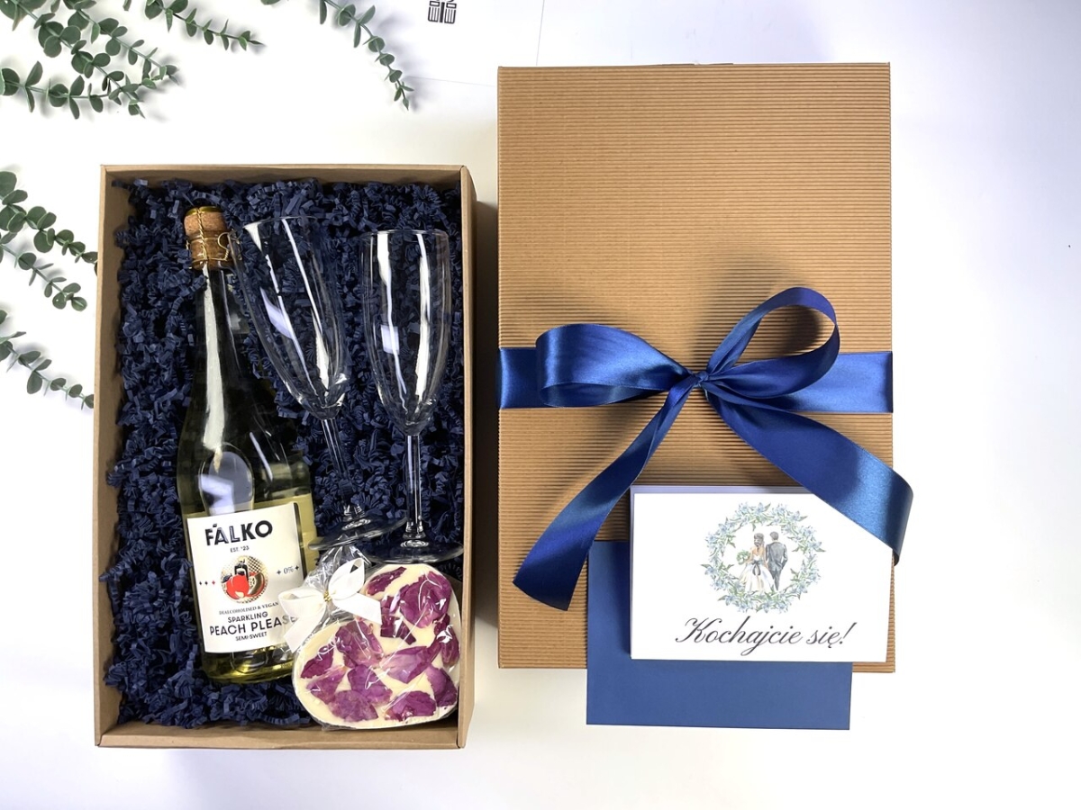 Elegancki box prezentowy na ślub z bezalkoholowym winem musującym, dwoma kieliszkami, słodkim upominkiem oraz personalizowaną kartką na pieniądze. Gotowy prezent dla Pary Młodej.