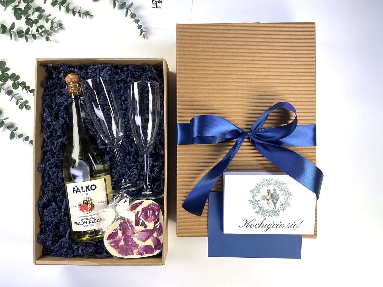 Elegancki box prezentowy na ślub z bezalkoholowym winem musującym, dwoma kieliszkami, słodkim upominkiem oraz personalizowaną kartką na pieniądze. Gotowy prezent dla Pary Młodej.