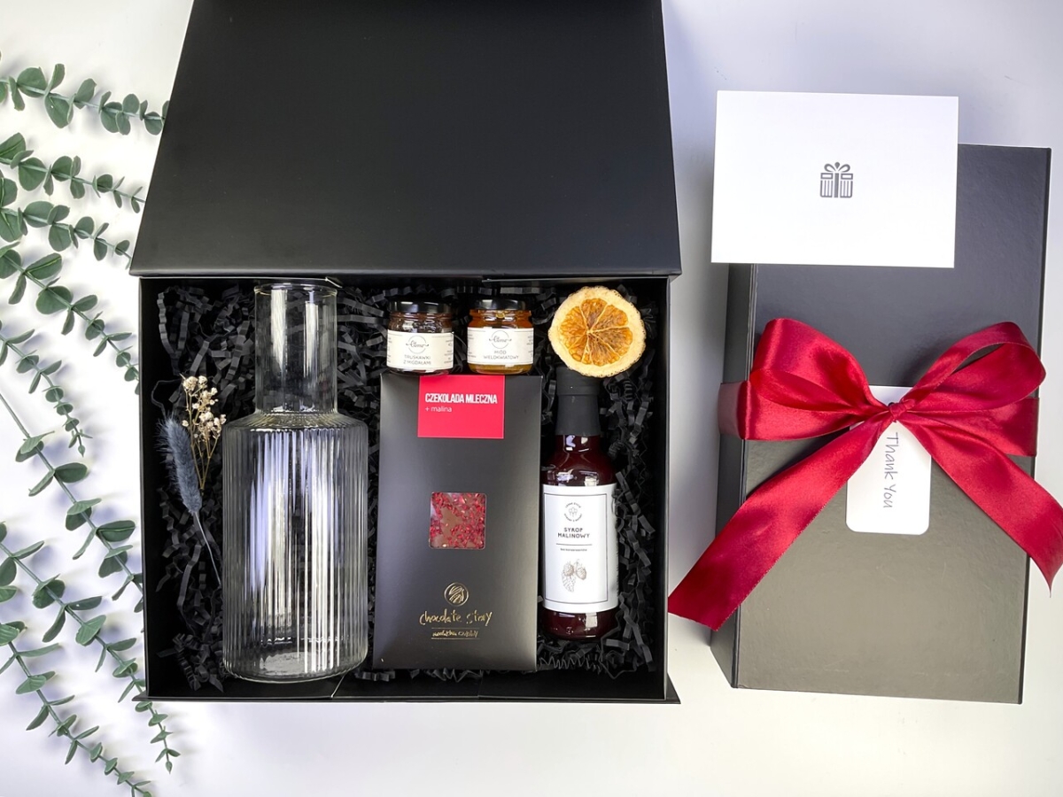 Elegancki box prezentowy z designerską szklaną karafką, syropem malinowym, miodami smakowymi, rzemieślniczą czekoladą oraz personalizowaną kartką. Idealny prezent premium.