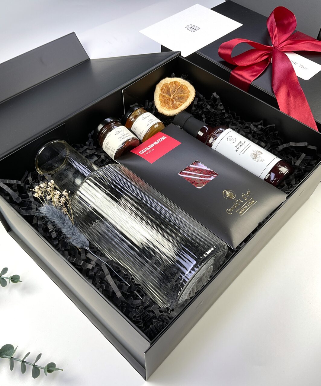 Gotowy box prezentowy klasy premium z ryflowaną karafką, syropem malinowym, miodami smakowymi i czekoladą mleczną z malinami. Możliwość personalizacji kartki.