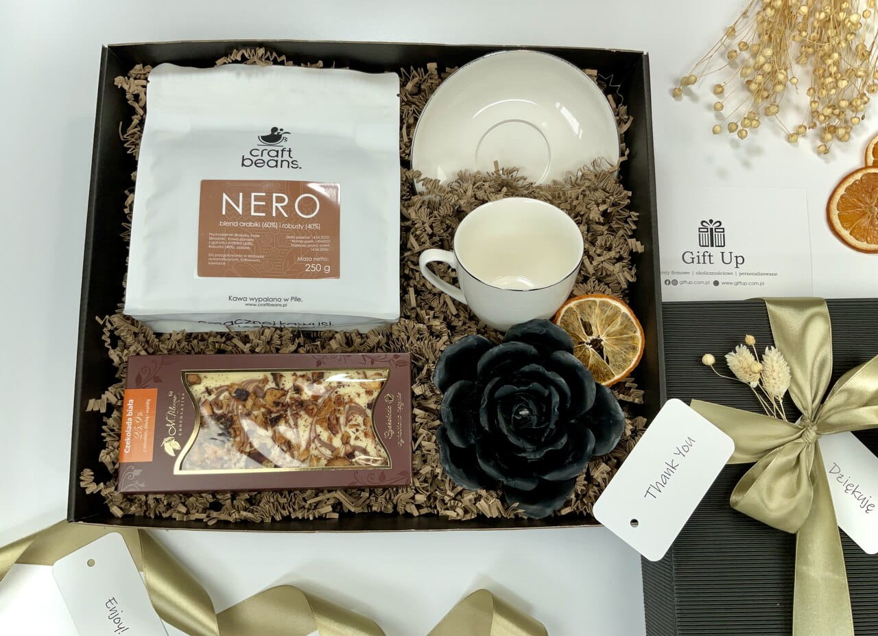 zestaw box kosz prezentowy firmowy z kawą ziarnistą porcelanową białą filiżanką ze złotym rantem naturalną czarną świecą z wosku pszczelego i przepyszną ręcznie robioną białą czekoladą z miodem cynamonem i jabłkami