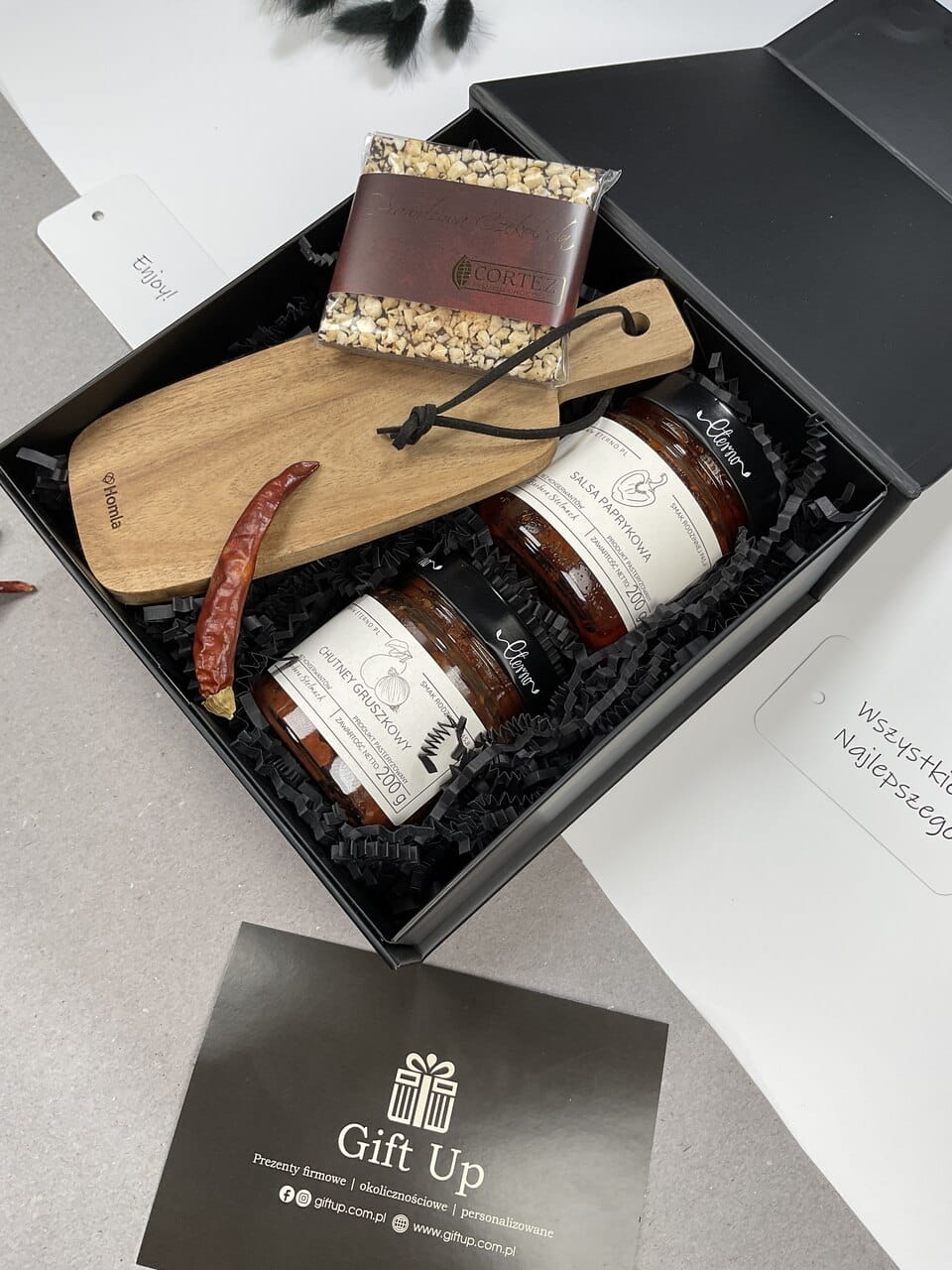 wytrawny elegancki prezent na Dzień Chłopaka, box z drewnianą elegancką deską do serwowania, deska do serów, deska do krojenia naturalna salsa paprykowa ostra chutney gruszkowy i słodka czekolada świąteczna z dodatkami