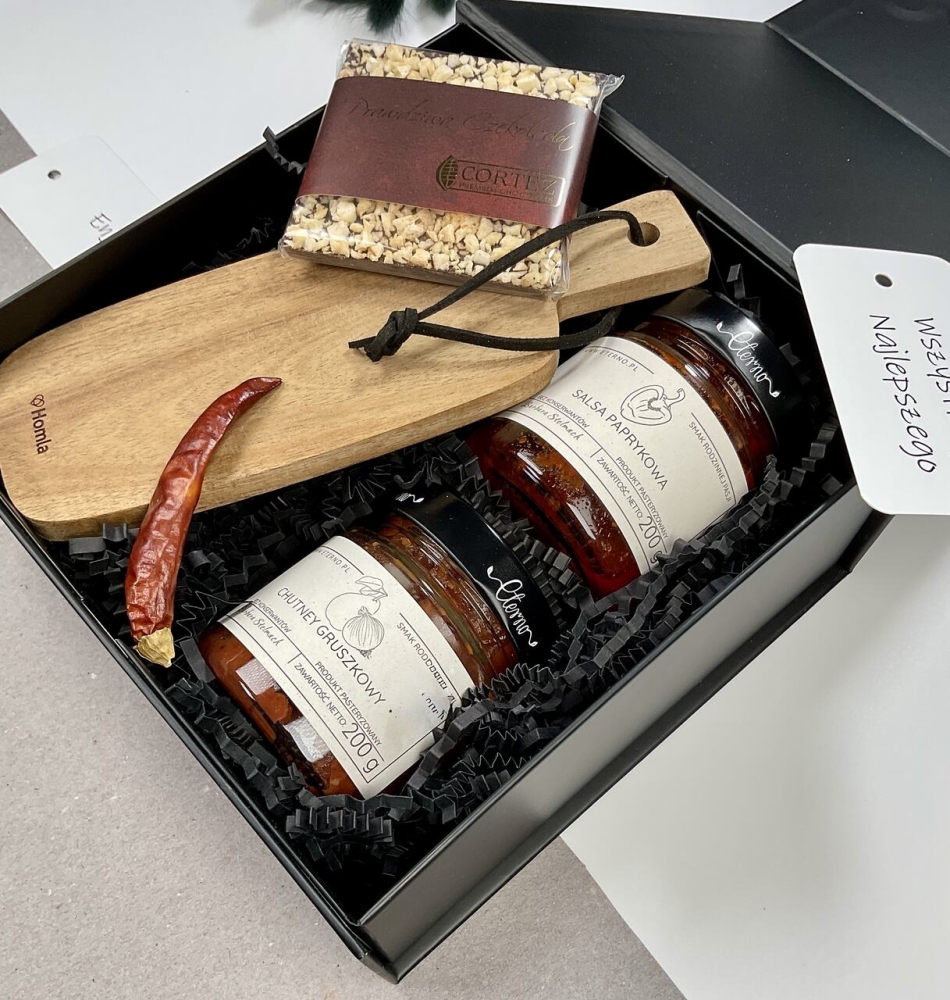 wytrawny elegancki prezent na Dzień Chłopaka, box z drewnianą elegancką deską do serwowania, deska do serów, deska do krojenia naturalna salsa paprykowa ostra chutney gruszkowy i słodka czekolada świąteczna z dodatkami